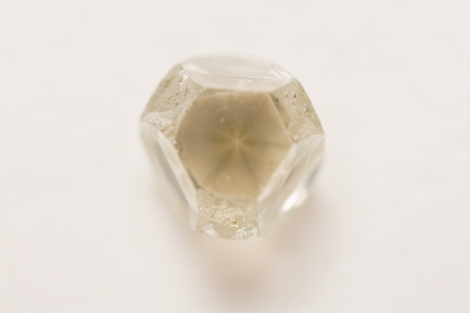 A natural diamond crystal in its rough, uncut octahedral form on a plain background
