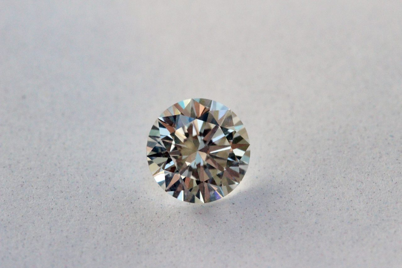 A loose modern round brilliant cut diamond on a plain white background, showing fine even faceting and a pointed culet
