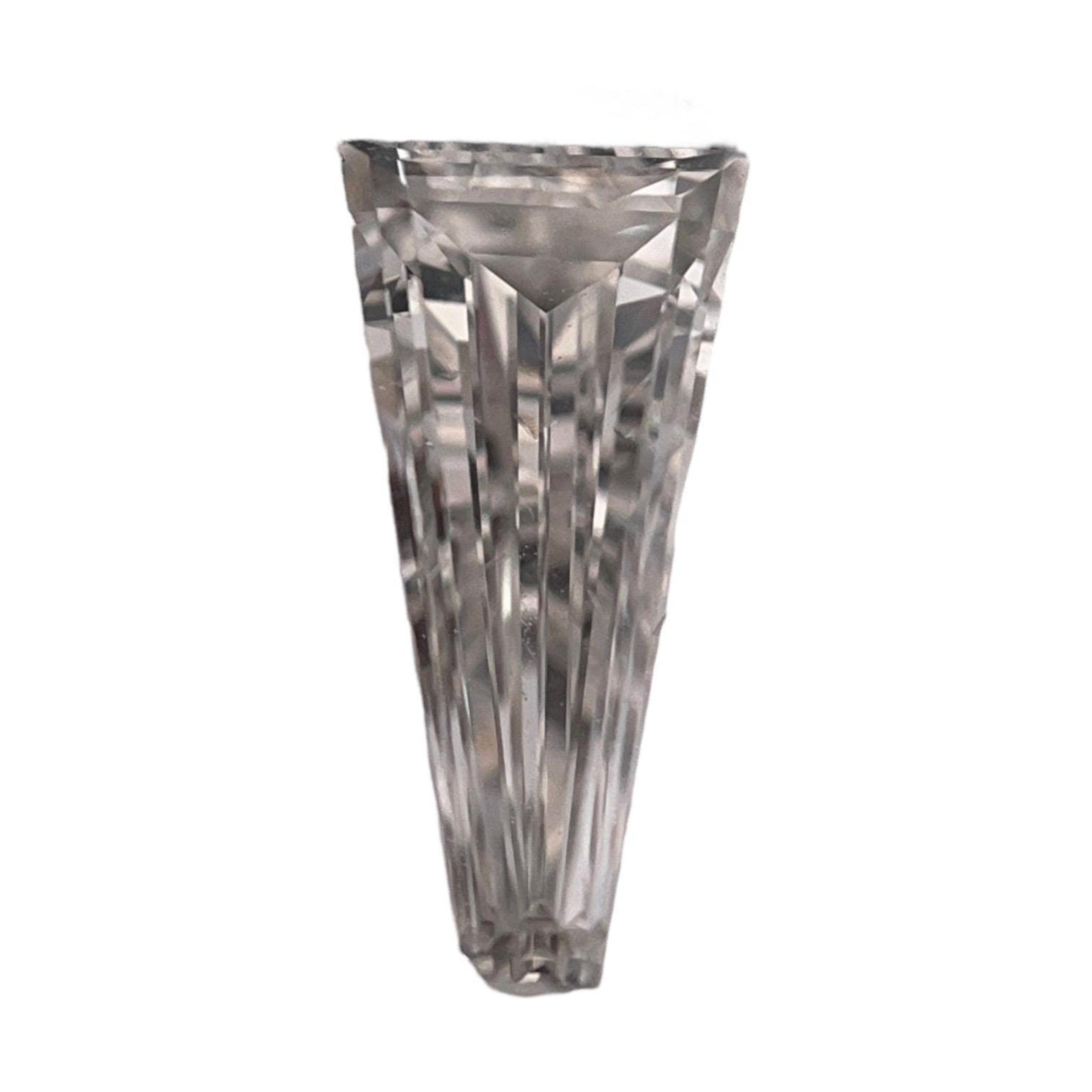 A single loose tapered baguette diamond lying face up on a white background, broad across the top edge and narrowing steadily toward the bottom, with long step cut facet rows running down both long sides.
